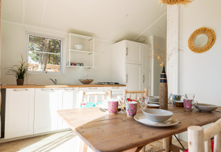 Lichte, gezellige keuken en eethoek in Le Bellevue – Cottages en lodges Vendée, ideaal voor glamping.
