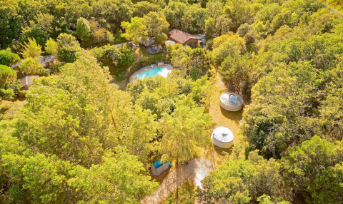 Aerial view of Camping des Randonneurs - Yurts Occitanië featuring a pool, yurts, and lush green trees.