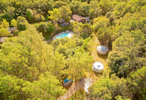 Vista aerea di Camping des Randonneurs - Yurts Occitanië con yurts, piscina e alberi rigogliosi.