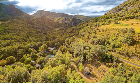 Aerial view of Camping des Randonneurs - Yurts Occitanië, blending yurts and nature in the green hills.