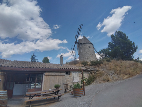 Alojamiento glamping y camping en Camping des Randonneurs - Yurts Occitanië con un molino y cielo azul.