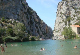 Personas nadando en un río entre acantilados rocosos cerca de Camping des Randonneurs - Yurts Occitanië en Francia sur.