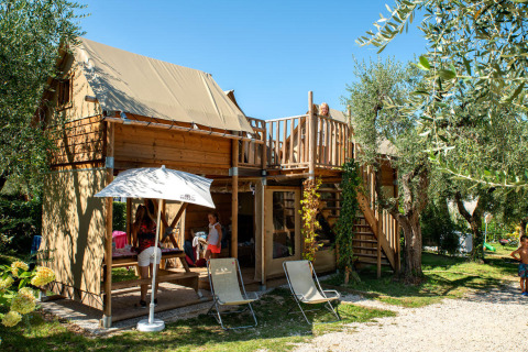Famiglia in vacanza al Chianti Glamping Resort - Air Dreamer Toscane con struttura in legno e spazio esterno.