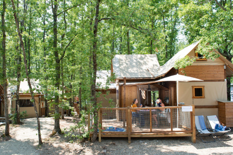 Glampingaccommodatie Chianti: Air Dreamer Toscane met houten tent en terras in bosrijke omgeving.