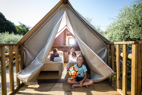 Børn leger foran glampingtelt på Chianti Glamping Resort, Vacanze col Cuore, Air Dreamer Toscane.