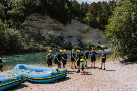 Un gruppo con caschi si prepara per il rafting vicino al fiume a River Camping Bled - Lodges Slovenië, Slovenia.