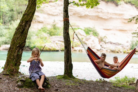 Des enfants profitent du camping au bord de la rivière avec un hamac à River Camping Bled en Slovénie.