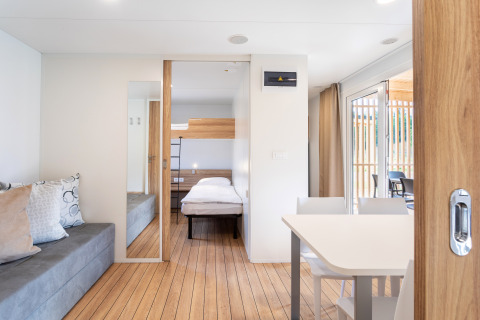 Moderne glamping accommodatie bij River Camping Bled - Lodges Slovenië met lichte kamers en een terras.