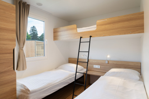 Moderne glamping accommodatie bij River Camping Bled - Lodges Slovenië met stapelbed en eenpersoonsbedden.