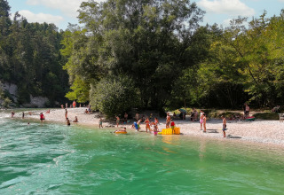 Personas disfrutan de la playa y el agua en River Camping Bled - Lodges Slovenië, rodeados de naturaleza.