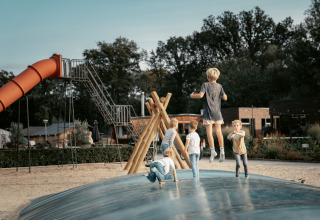 Kinderen spelen op een speelplaats met luchtkussen bij Vakantiepark de Italiaanse Meren, Glamping Gelderland.