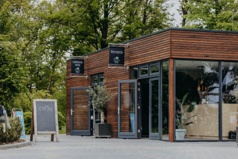 Ingresso di Vakantiepark de Italiaanse Meren - Glamping Gelderland con lavagna da caffè all’esterno.