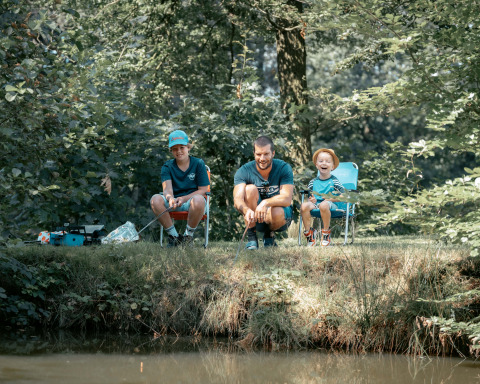 Famiglia che pesca insieme vicino all'acqua durante il soggiorno al Vakantiepark de Italiaanse Meren - Glamping Gelderland.