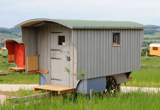 Hébergement glamping en roulotte à Hofgut Hopfenburg, Baden-Württemberg, entouré par la nature.