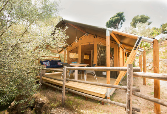 Glamping indkvartering 'Little Canvas Escape - Lodgetenten Ameland' med terrasse og træstakit foran.