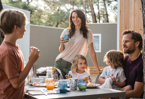 Familia disfruta de un desayuno al aire libre en Falkenstein Premium Camping Zadar - Mobile Homes en Dalmacia.