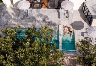 Luchtfoto van het zwembad met twee personen, ligbedden en parasols bij Falkenstein Premium Camping Zadar.