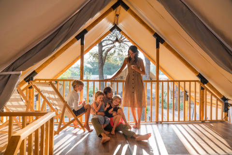 Family relaxing together in a glamping tent at Falkenstein Premium Camping Zadar, Mobile Homes in Dalmatia, Croatia.