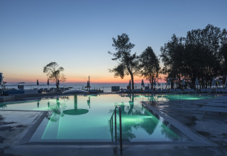 Piscina exterior al atardecer en Falkenstein Premium Camping Zadar - Mobile Homes en Dalmacia, Croacia.