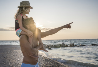 Vader en dochter bij zonsondergang aan het strand op Falkenstein Premium Camping Zadar - Mobile Homes in Dalmatië.