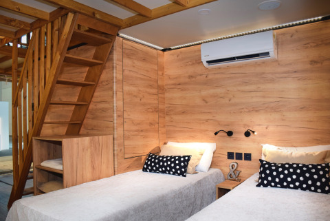 Alloggio glamping moderno al Falkenstein Premium Camping Zadar con letti singoli e arredo in legno.