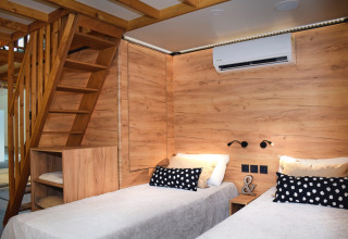 Modern glamping accommodation at Falkenstein Premium Camping Zadar with twin beds and wooden finishes.