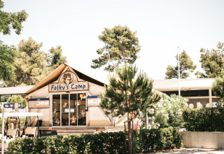 Indgang til Falky's Camp ved Falkenstein Premium Camping Zadar, omgivet af grønne træer og buske.