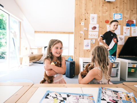 Kinderen spelen met knuffels in een lichte, moderne binnenruimte bij Falkenstein Premium Camping Zadar, Dalmatië.