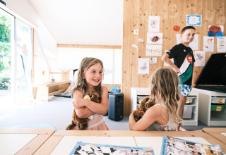 Børn leger med bamser i en lys, moderne indendørs legeplads på Falkenstein Premium Camping Zadar, Kroatien.