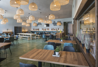 Gezellig restaurant met houten tafels en designlampen bij Falkenstein Premium Camping Zadar in Dalmatië.