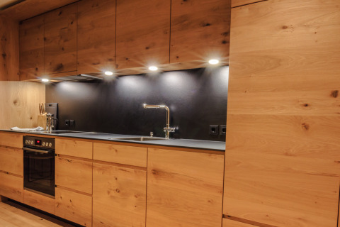 Moderne keuken in het Premium chalet van Wirthshof Resort aan de Bodensee, met houten accenten en LED-verlichting.