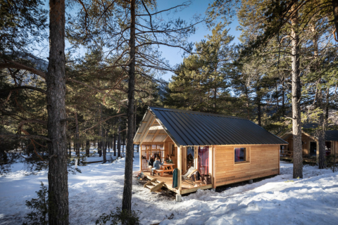Hytopia Winter Chalets – La Clarée glamping i de franske Alper med sneklædte træer og en træhytte.