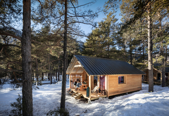 Hytopia Winter Chalets – La Clarée glamping i de franske Alper med sneklædte træer og en træhytte.