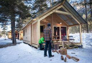Winter glamping at Huttopia Winter Chalets – La Clarée in the French Alps, wooden cabin in snowy forest.