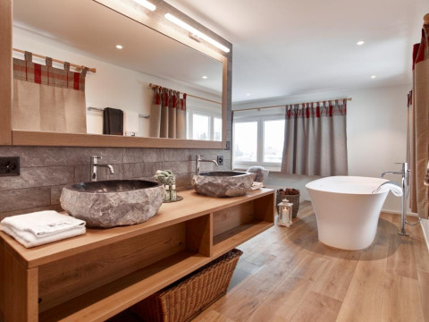 Modernes Badezimmer bei Glamping Atzmännig - PODhouses & Lodges See-Gaster mit Steinwaschbecken und freistehender Badewanne.