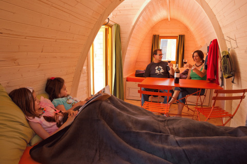 Famiglia rilassata in un pod di legno a Glamping Atzmännig - PODhouses & Lodges See-Gaster in Svizzera.