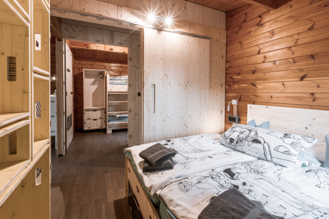 Chambre du glamping Destinature Dorf Südeifel - Chalets Eifel, avec murs en bois et lit confortable.