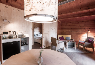 Interior of a modern wooden cabin with cozy living area and bedroom at Destinature Dorf Südeifel.