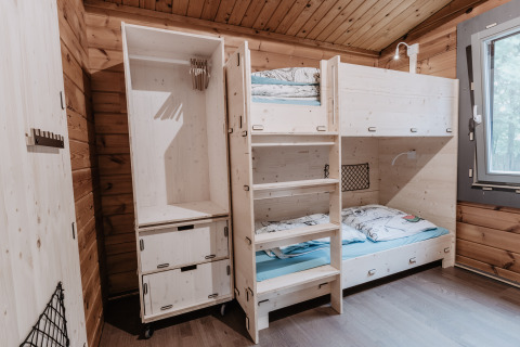 Cozy glamping accommodation with wooden bunk beds in Destinature Dorf Südeifel - Chalets Eifel, bright room.