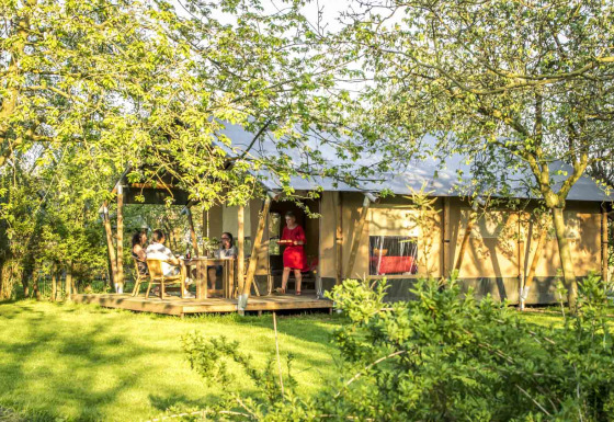Glamping-Safaritent bei Voedselbron Graauw in Zeeland, Niederlande, umgeben von grüner Natur und Gästen.