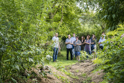 Un grupo de personas recorre un jardín verde en Voedselbron Graauw - Safaritenten Zeeland glamping.
