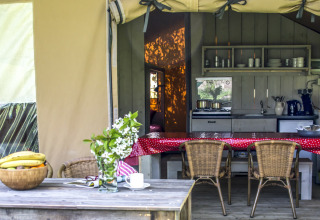 Cucina e zona pranzo da glamping accoglienti presso Voedselbron Graauw Safaritenten Zeeland, con arredi rustici.