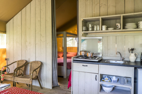 Alojamiento glamping en Voedselbron Graauw - Safaritenten Zeeland con cocina y dormitorio acogedor.