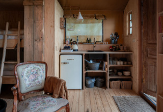 Gezellige inrichting van Smûk Recreatie - Lodgetenten Friesland met landelijke keuken en comfortabele zitplaats.
