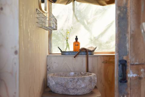 Rustieke stenen lavabo en koperen kraan, houten badkamer, Smûk Recreatie - Lodgetenten Friesland.