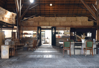 Intérieur rustique de glamping chez Smûk Recreatie - Lodgetenten Friesland avec bottes de foin et espace convivial.