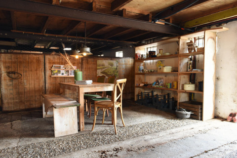 Rustikale Inneneinrichtung einer Glamping-Unterkunft mit Holztisch und Regalen bei Smûk Recreatie Friesland.