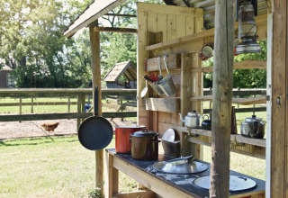 Udendørs køkken med gryder, pander og service på gård ved Smûk Recreatie - Lodgetenten Friesland, Holland.