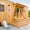 Wooden SONNENTOR - Lofts Oostenrijk glamping accommodation with terrace, lounge chair, and steps outdoors.
