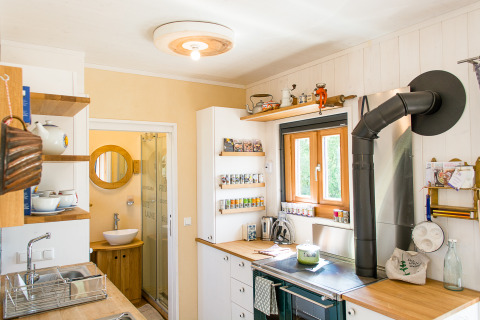 Gemütliche Küche in SONNENTOR - Lofts Oostenrijk Glamping mit Holzdetails und Tageslichtfenster.